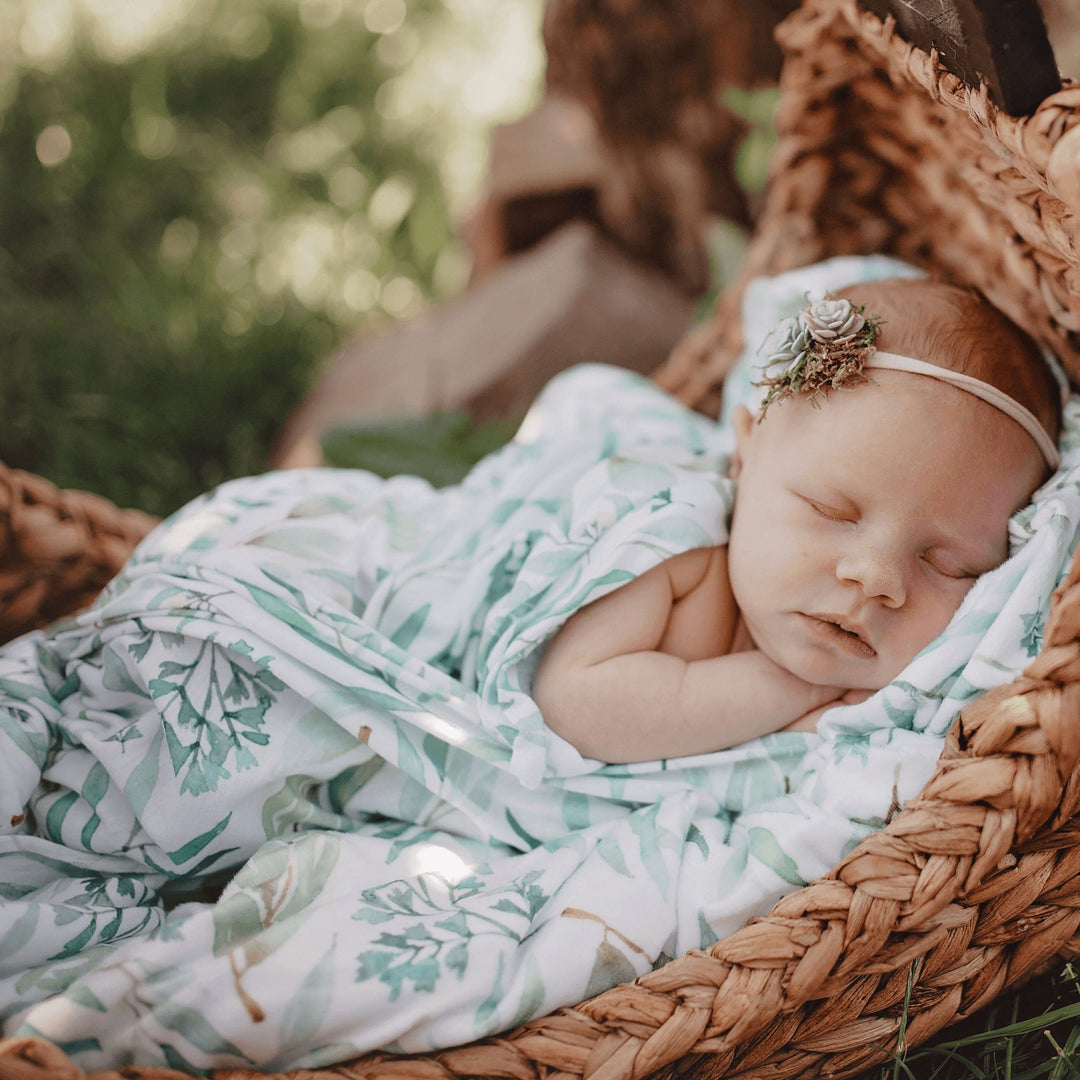 Baby peacefully sleeping in a GooseWaddle swaddle blanket.