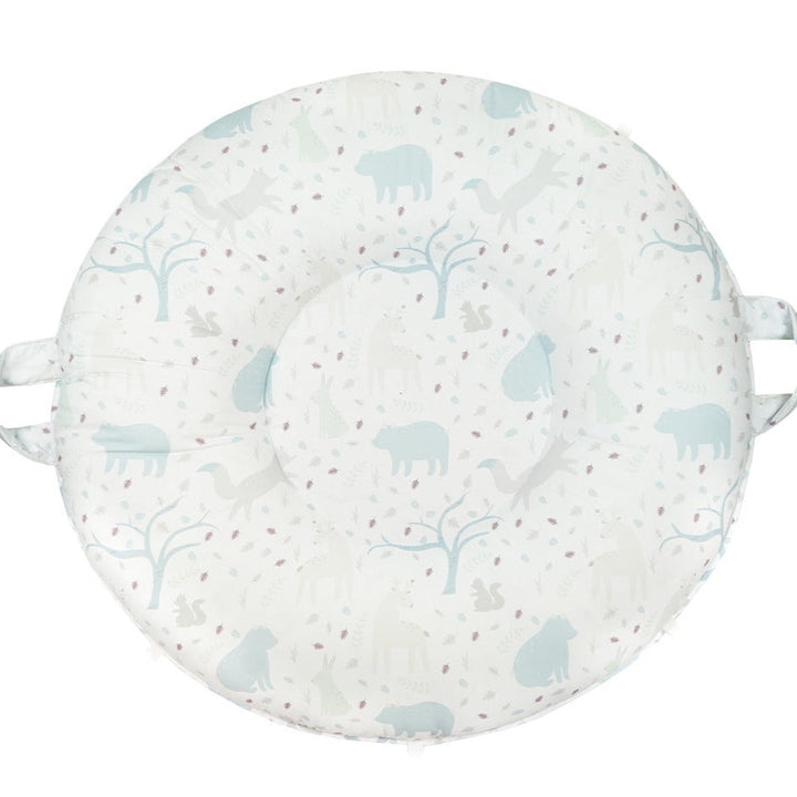 A round floor cushion with a pattern of trees and animals in blue and light gray tones, with a white background.
