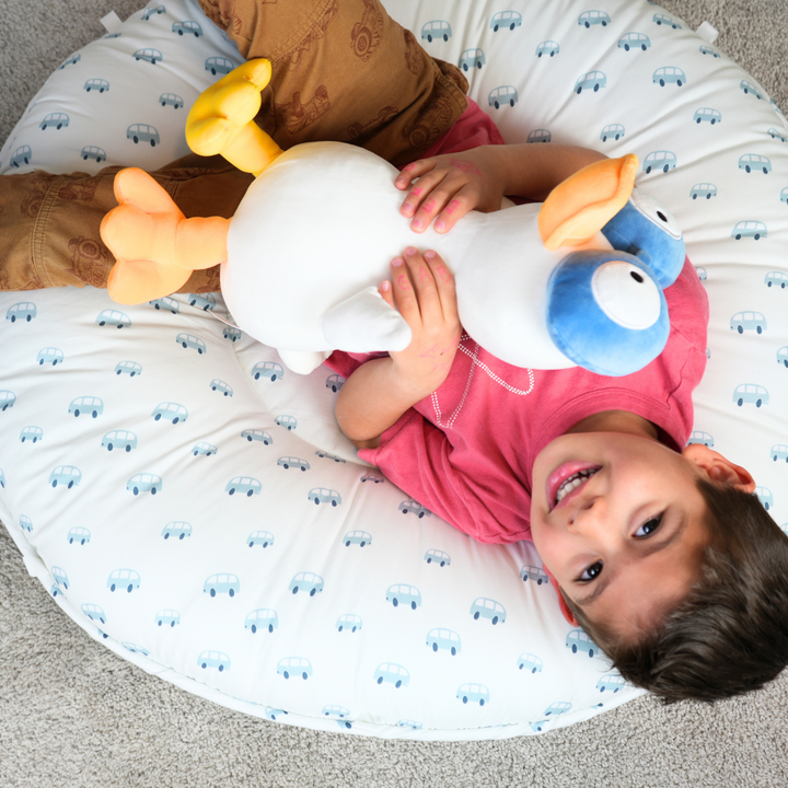 Tag Floor Cushion  A boy enjoys laying in this white with blue cars floor cushion.
