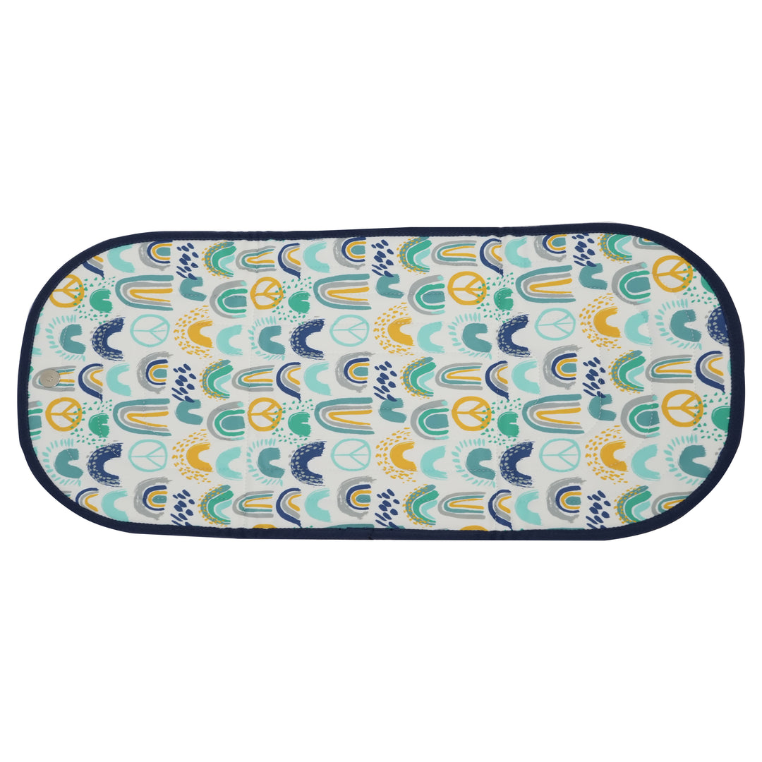 Patterned changing pad with abstract rainbow design on a white background.