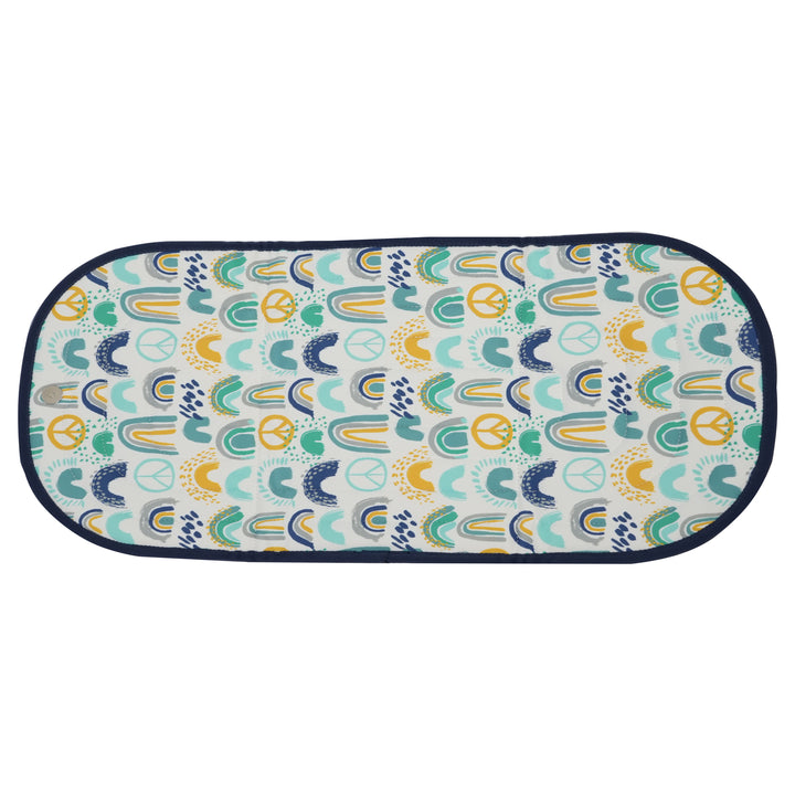 Patterned changing pad with abstract rainbow design on a white background.
