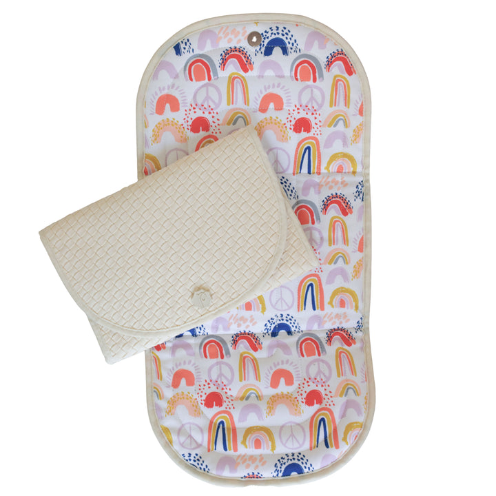 Baby changing mat with rainbow pattern on a white background